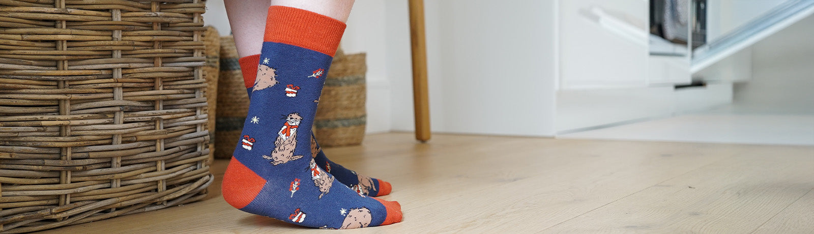 Person wearing blue christmas otter socks with red accents