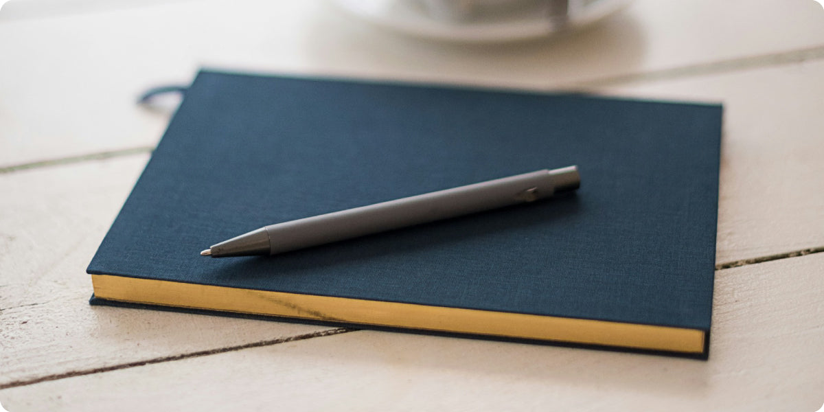 dark blue planner with a pen on it