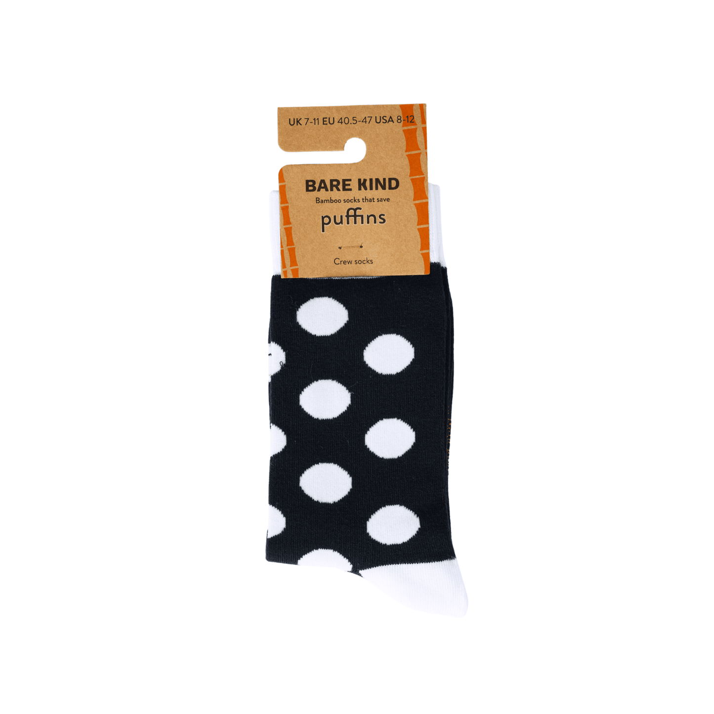 Black socks with white polka dots and a Bare Kind packaging label on a light gray background