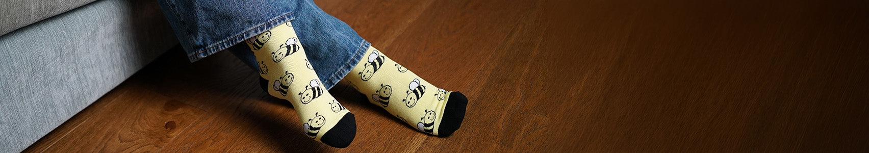 Person wearing bee socks on a wooden floor