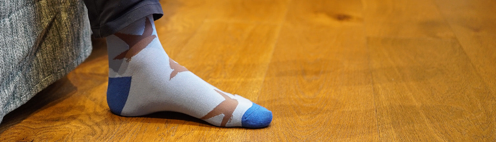 Blue socks with brown swift pattern on a wooden floor