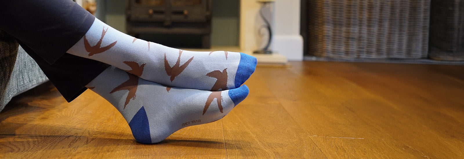 Person wearing socks with swift pattern on a wooden floor