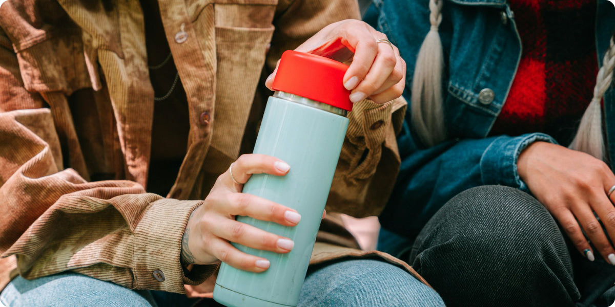 woman holding a green red tumbler in her hand