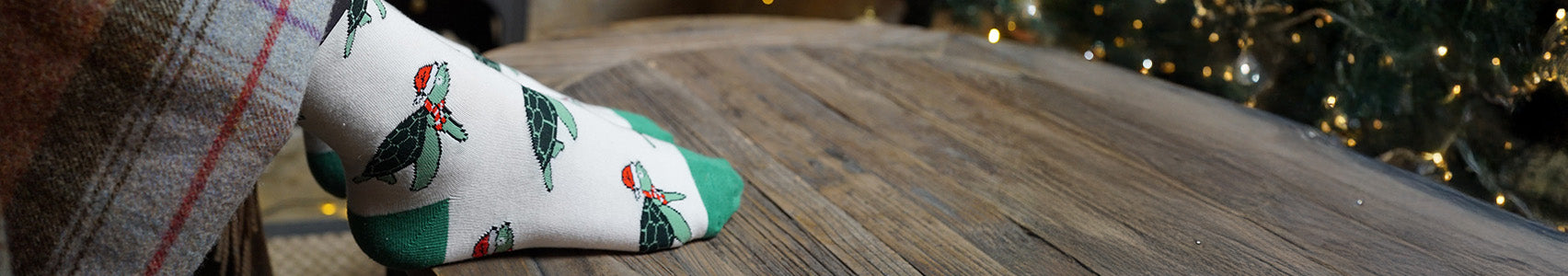 White sock with green turtle pattern on a wooden surface
