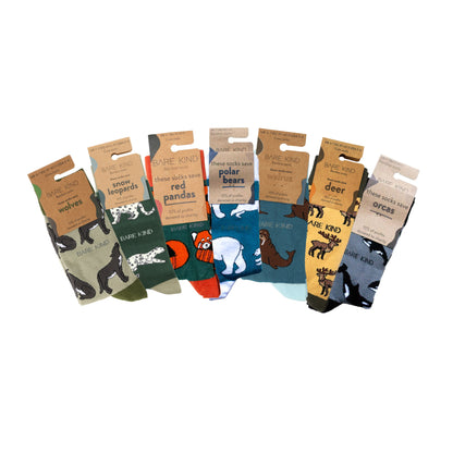 packaging flat lays of wolf, snow leopard, red panda, polar bear, walrus, deer, orca bamboo socks