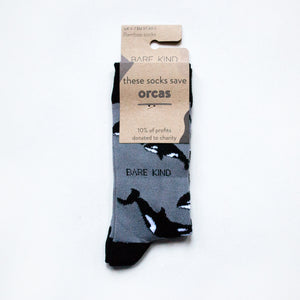 folded flat lay of black and grey orca bamboo socks in 100% recyclable cardboard packaging