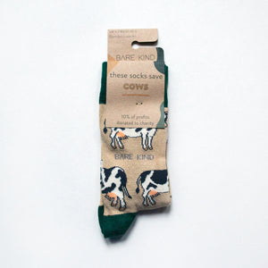 folded flat lay of cream and green cow bamboo socks in 100% recyclable cardboard packaging