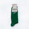 folded flat lay of emerald green ribbed bamboo socks with embroidered elephant motif on the cuff in 100% recyclable cardboard packaging