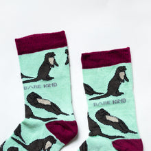 cuff closeup flat lay of pastel green otter socks for kids