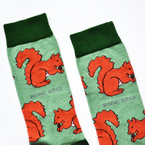 cuff closeup of flat lay of green bamboo socks with woven red squirrel design