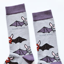 Flat lay of purple and grey bamboo socks with bats woven into the design. Image depicts a closeup of the cuffs