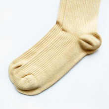 minimalist toe closeup flat lay of pastel yellow ribbed bamboo sock