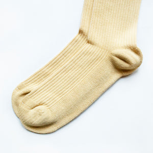 minimalist toe closeup flat lay of pastel yellow ribbed bamboo sock