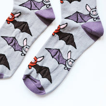 Flat lay of purple and grey bamboo socks with bats woven into the design. Image depicts a closeup of the toes