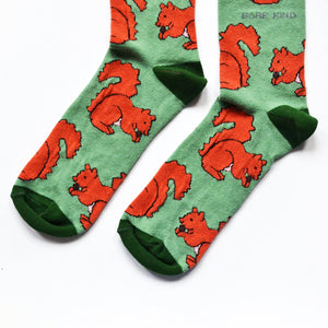 toe closeup flat lay of green bamboo socks with woven red squirrel design