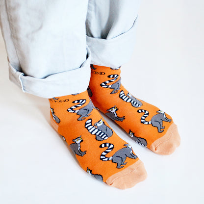 side angle view of model standing wearing orange lemur socks