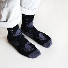 side angle view of model wearing black panther bamboo socks 
