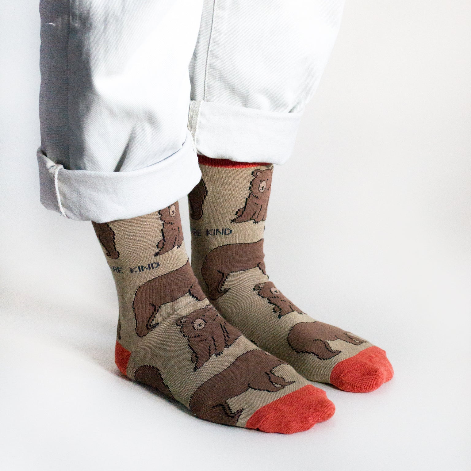 Model wears brown and red bamboo bear socks, side angle view, both feet on the floor as they stand