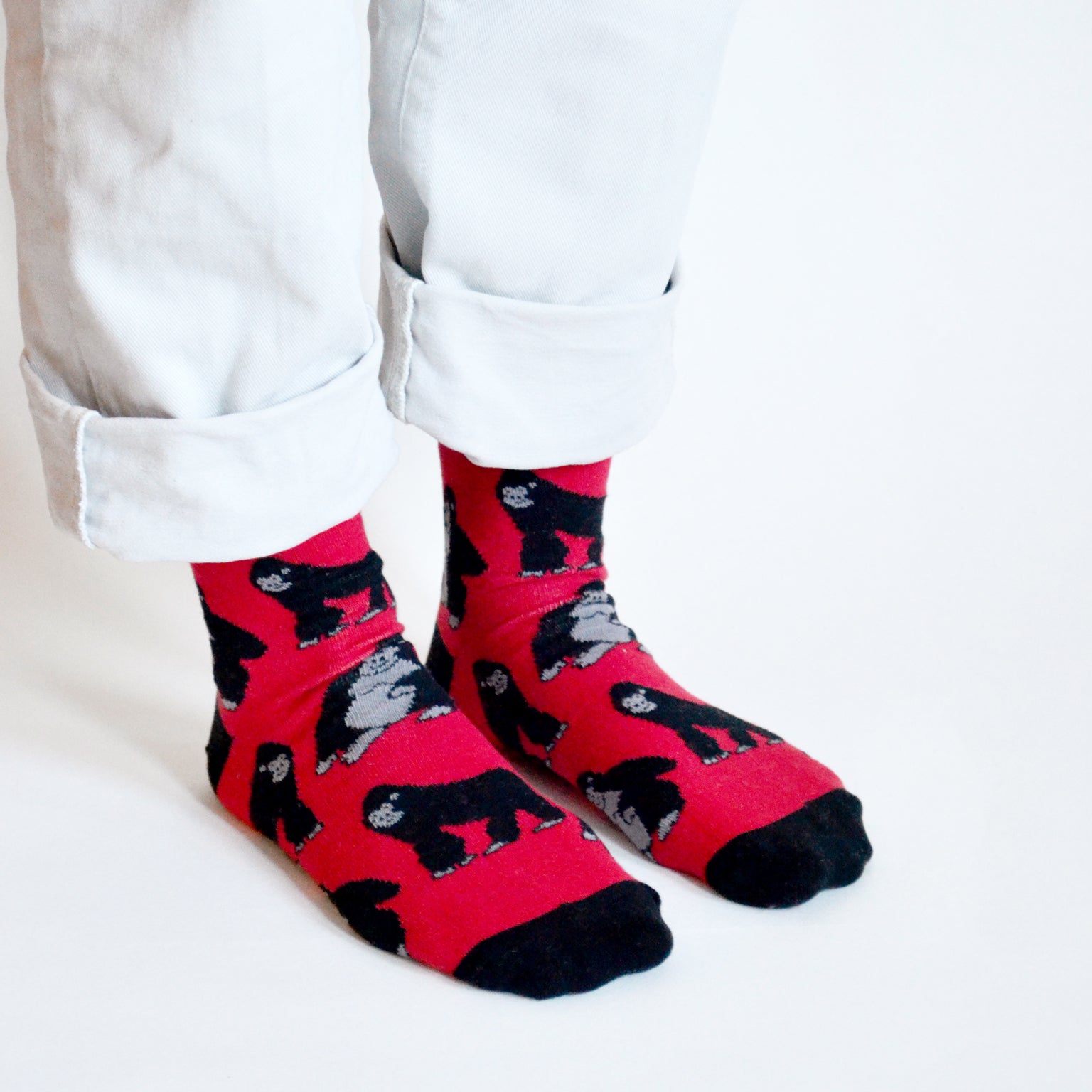 Standing model, side angle view, wearing red and black gorilla socks