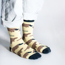side angle view of standing model wearing pastel yellow platypus bamboo socks