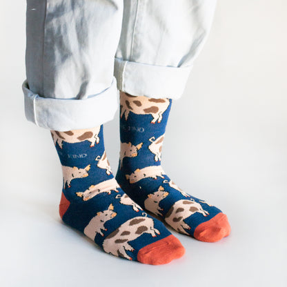 side angle view of standing model wearing navy blue pig bamboo socks