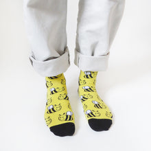 birds-eye view of a standing model wearing black and yellow bee bamboo socks