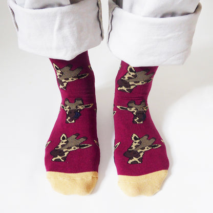 closeup of standing model wearing burgundy bamboo socks in giraffe print, front view