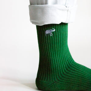 closeup of embroidered elephant motif as model is shown in a perfect side view wearing emerald green ribbed bamboo socks