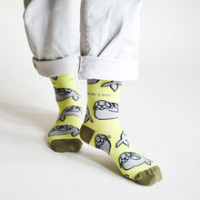 standing model wearing lime seal socks, left foot forward and heel up