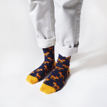 model standing, side angle view, wearing navy blue bamboo socks featuring leopard designs