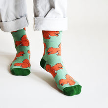 standing model wearing red squirrel bamboo socks puts left foot forward