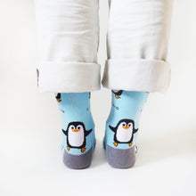 heel view of standing model wearing sky blue penguin bamboo socks