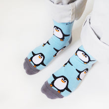 birds eye, side angle view of standing model wearing sky blue penguin bamboo socks