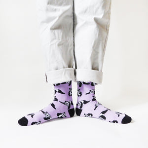 standing model wearing lilac panda socks with the feet pointing outwards and heels together, forming a line