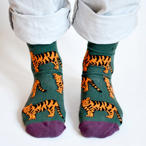 front view closeup of standing model wearing green tiger socks