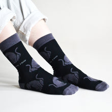side angle view of model sitting, wearing black panther bamboo socks 
