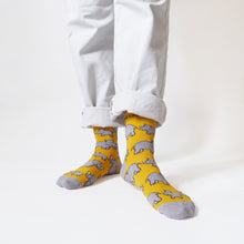 standing model wears yellow rhino socks, the left foot is forward and angled out