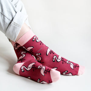 model sitting with ankles crossed wearing hot pink flamingo socks 