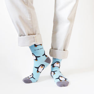 front view of standing model wearing sky blue bamboo penguin socks with the right heel lifted