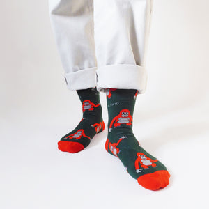 standing model wearing orangutan socks, left foot forward and toes angled out